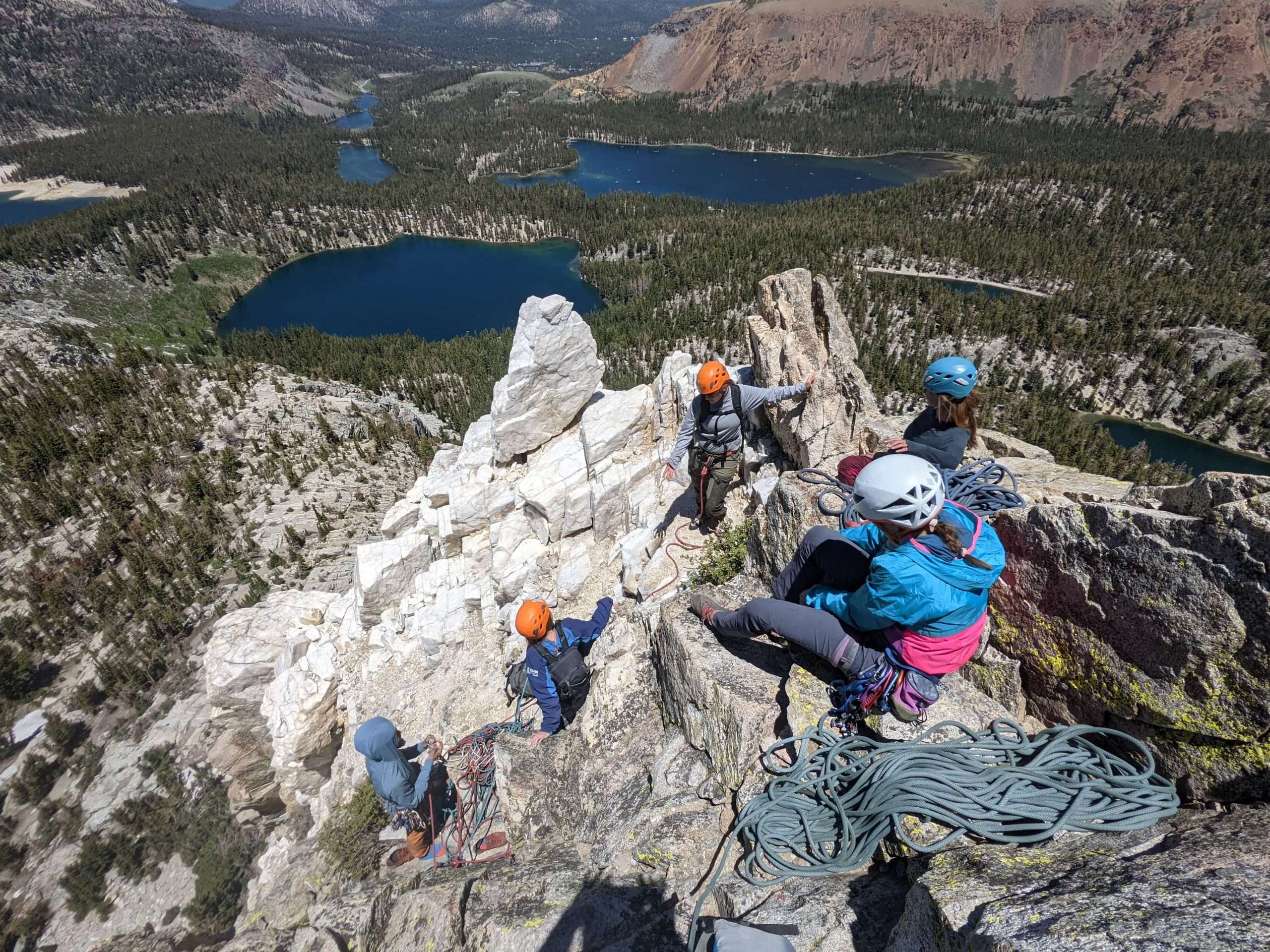 A group of climbers getting ready to descend into a valley full of mountain lakes.