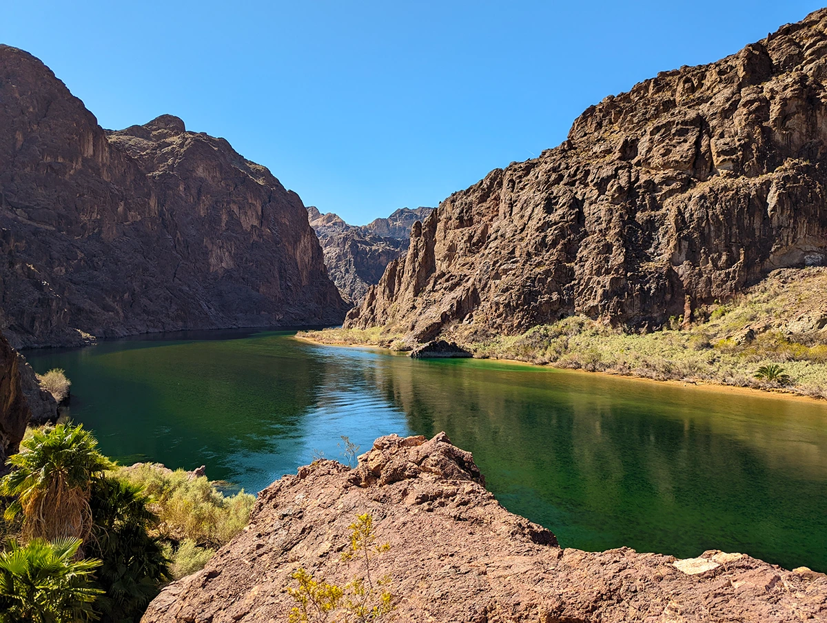 View overlooking the river running through the canyon with the jagged canyon walls rising up on each side.